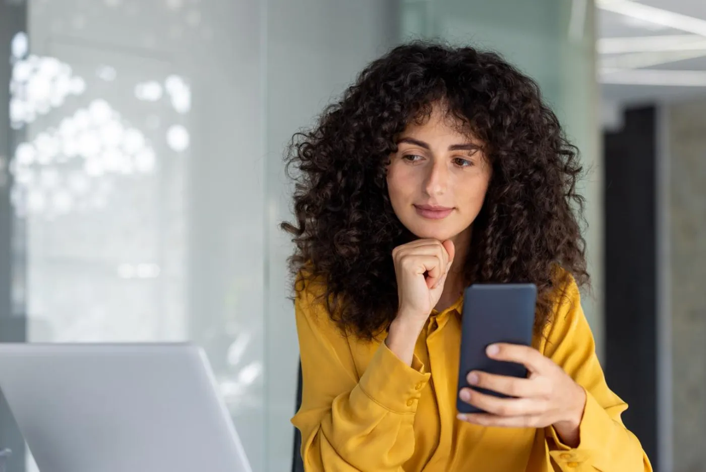 A relaxed business owner sitting calmly with her phone, hands-off, while her AI agents handle the work