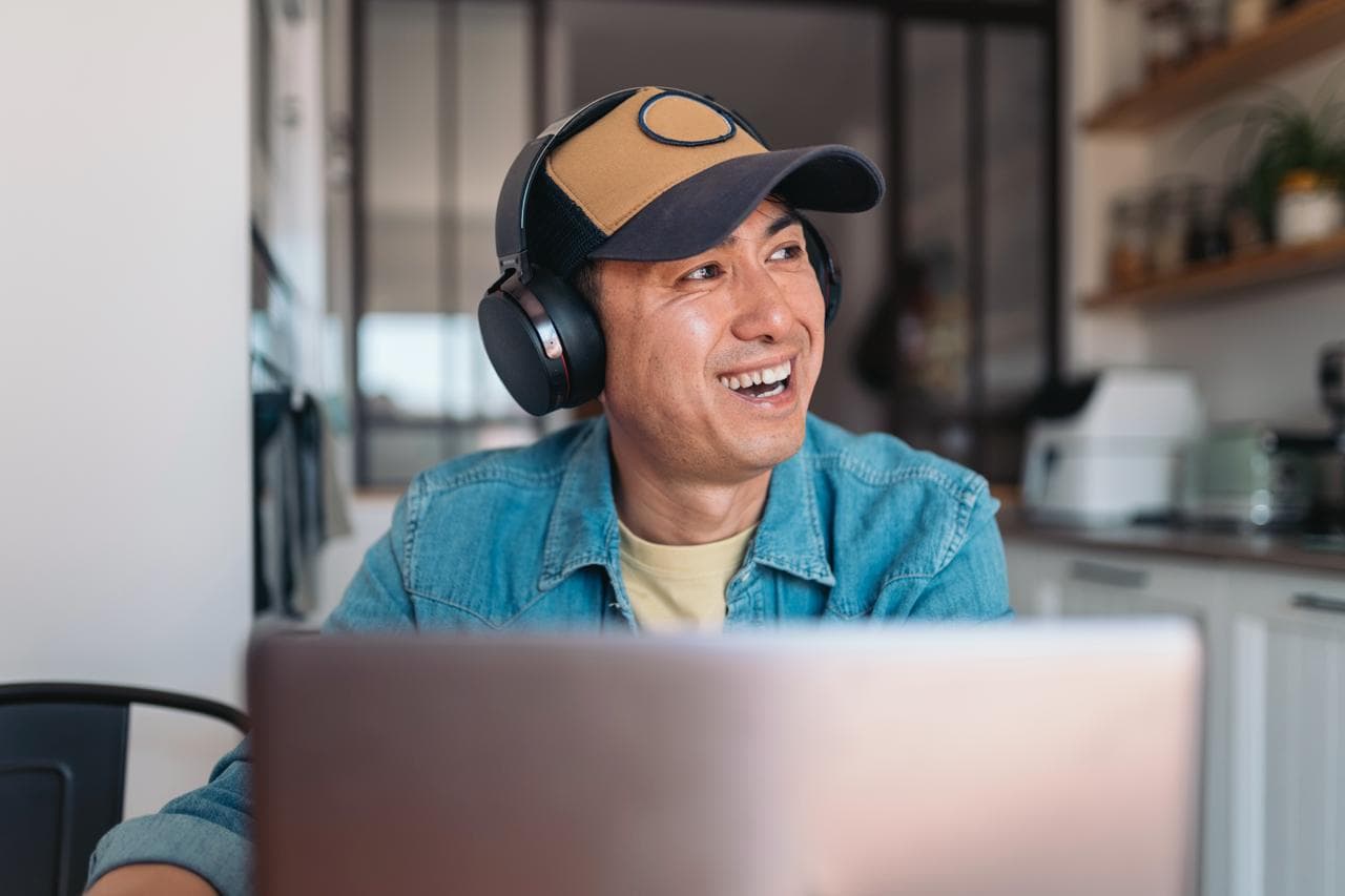 A relaxed business owner working calmly at a laptop while their AI agents run the operations in the background